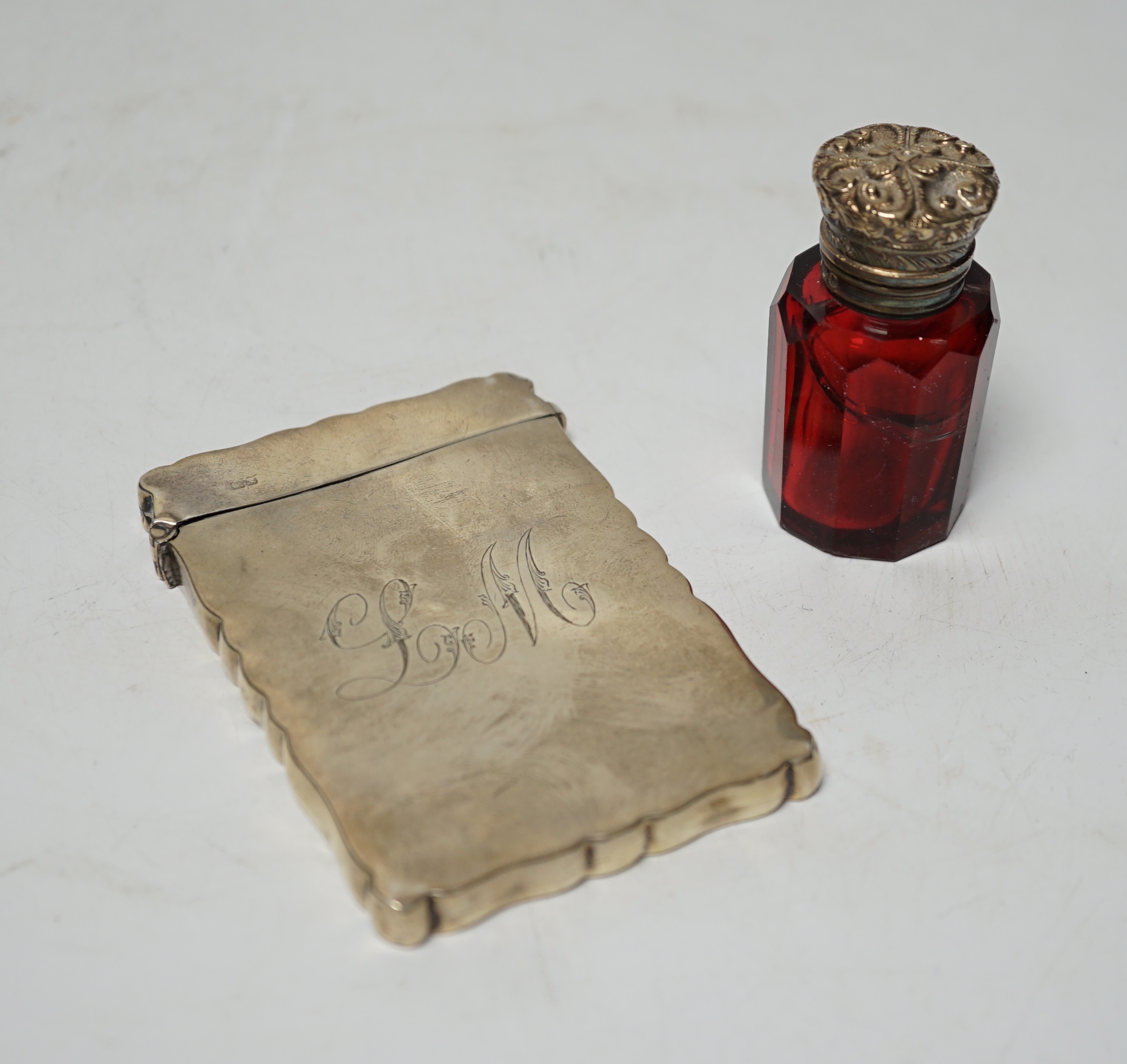 A late Victorian silver mounted ruby glass scent bottle, Birmingham, 1897, 61mm and a later silver card case (a.f.).